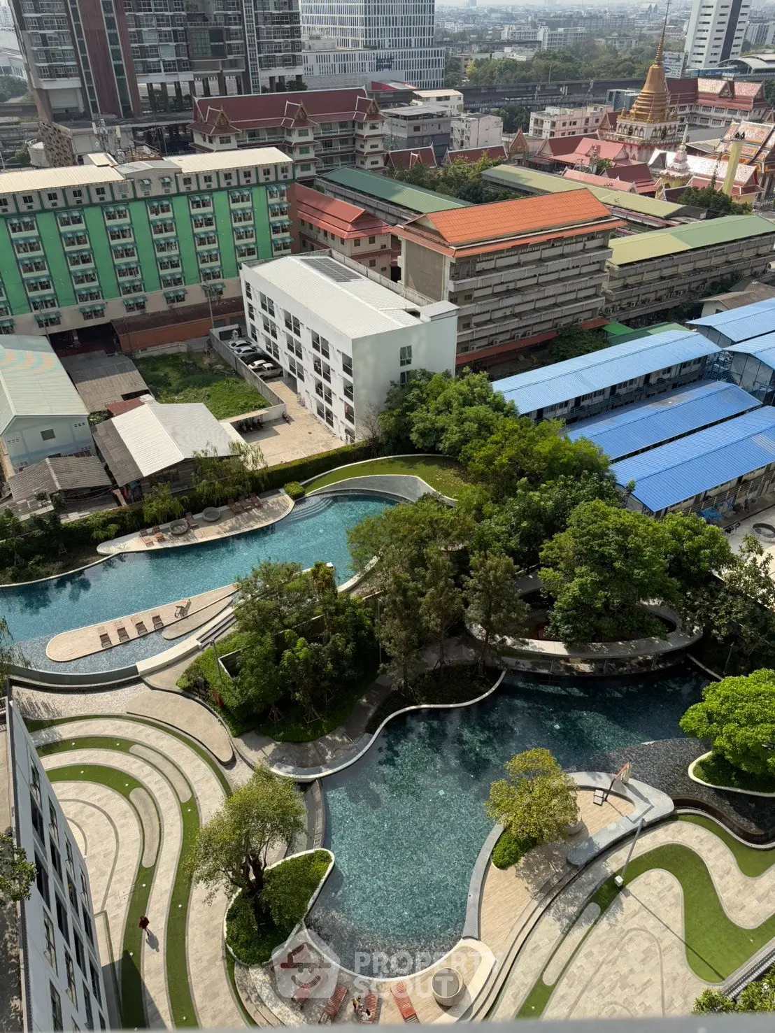 Stunning aerial view of modern residential complex with lush gardens and inviting swimming pools.