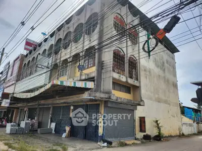 Commercial building exterior with closed shutters and street view, ideal for business opportunities.