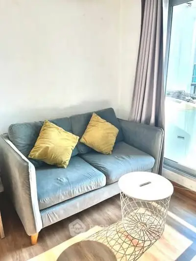 Cozy living room with stylish sofa and natural light, perfect for relaxation.