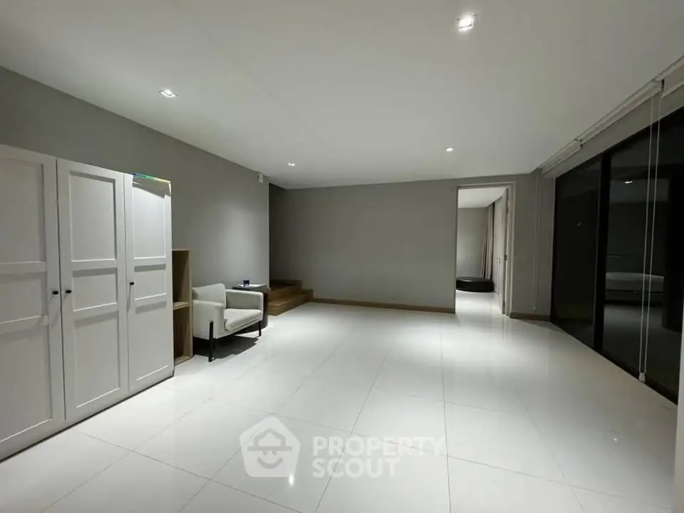 Spacious minimalist living room with sleek white tiles and modern furniture