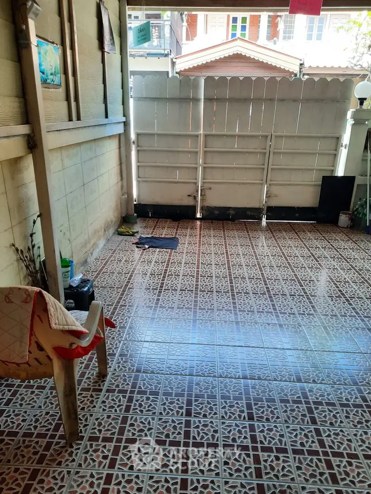 Charming tiled patio with privacy fence and cozy seating area