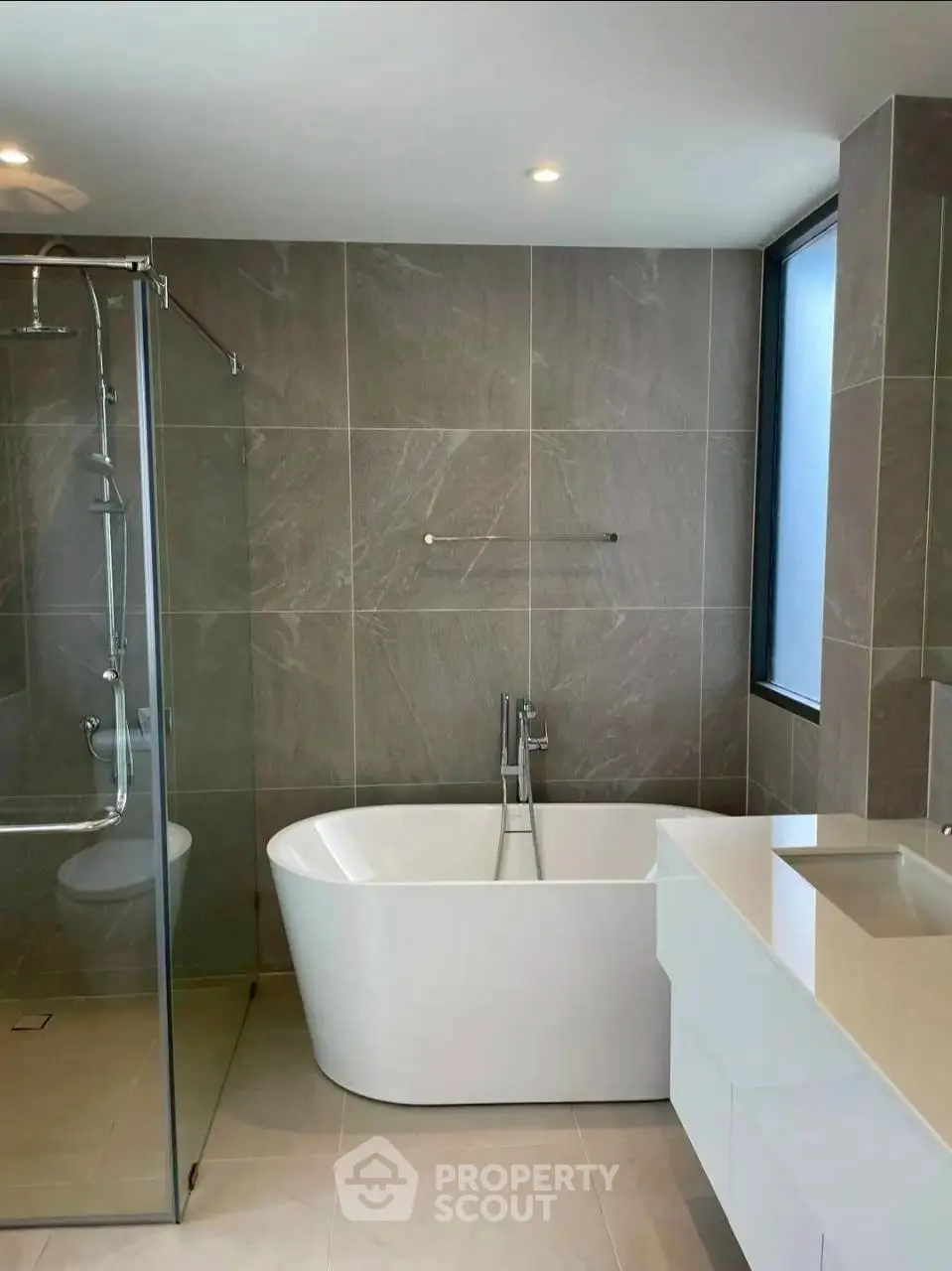 Luxurious modern bathroom with freestanding bathtub and glass shower enclosure.