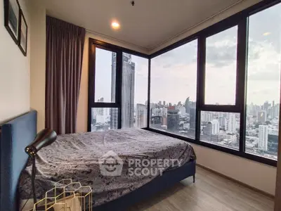 Stunning bedroom with panoramic city views and modern decor in high-rise apartment.