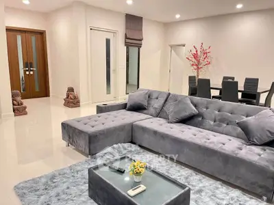 Luxurious modern living room with plush gray sectional sofa and elegant dining area