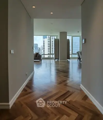 Spacious modern living room with elegant wooden flooring and city view.