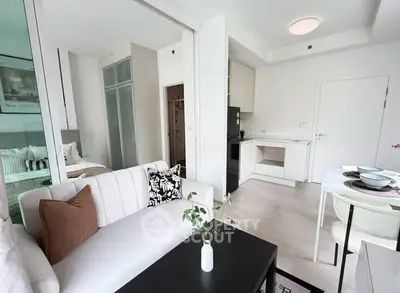 Modern open-plan living room and kitchen with stylish decor and natural light.