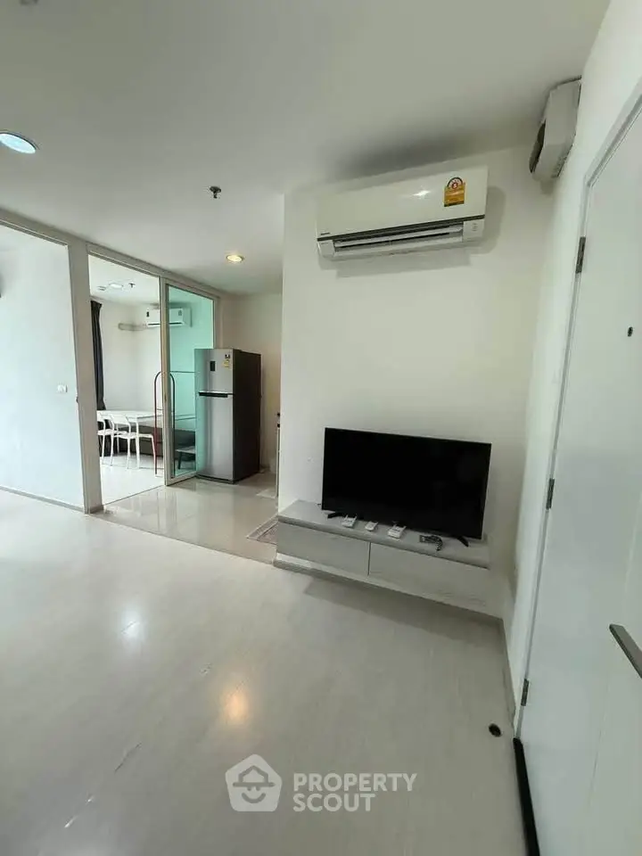 Modern living room with air conditioning and sleek TV setup in a stylish apartment.
