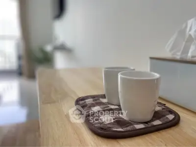 Cozy kitchen counter with two mugs on a checkered mat, perfect for morning coffee.