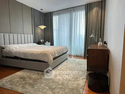 Luxurious bedroom with modern decor and large windows offering natural light.