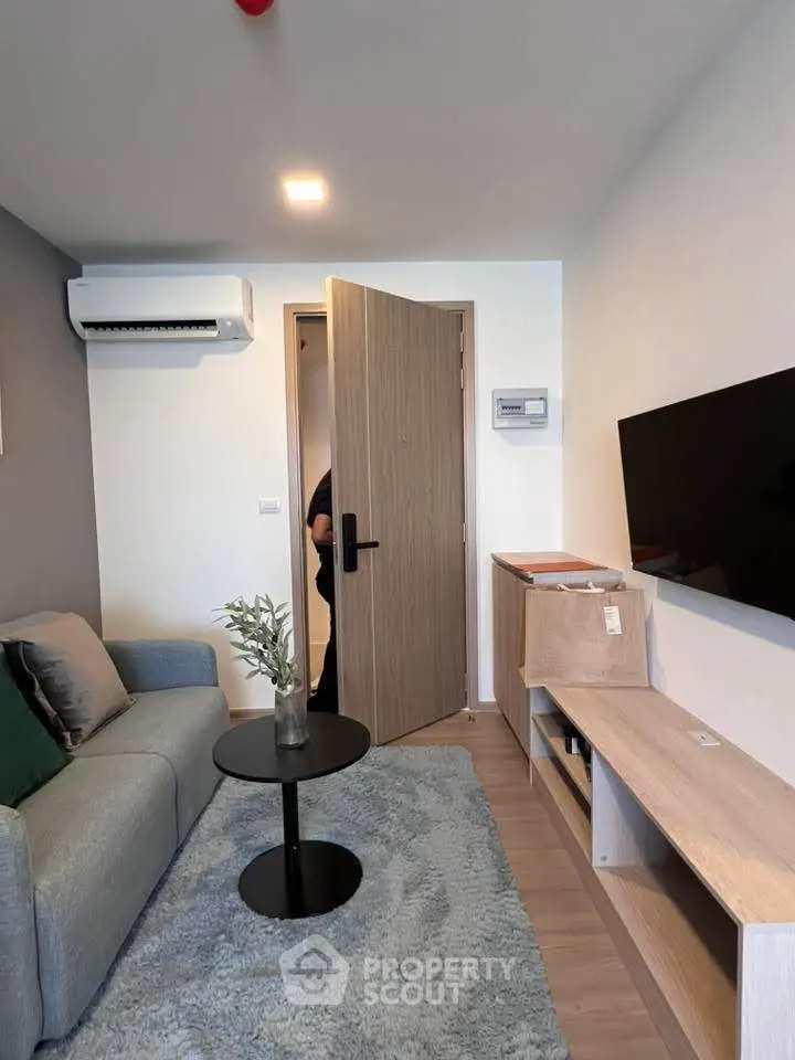 Cozy living room with modern decor, featuring a sleek TV setup and comfortable seating.