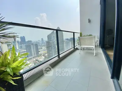 Stunning high-rise balcony with panoramic city views and modern seating area.