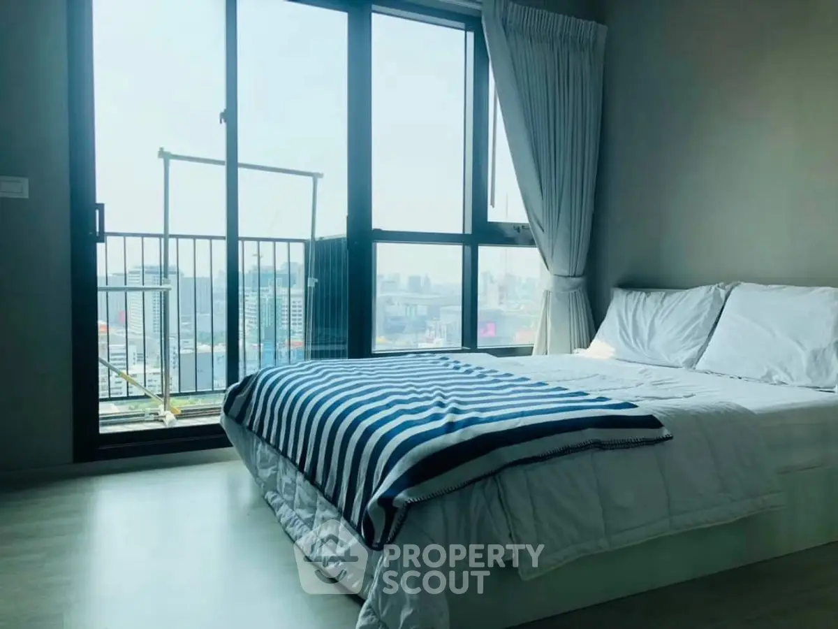 Bright bedroom with city view and balcony access in modern apartment