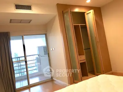 Spacious bedroom with balcony and built-in wardrobe in modern apartment