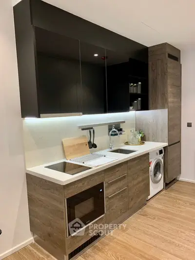 Modern kitchen with sleek cabinets, built-in appliances, and wooden flooring