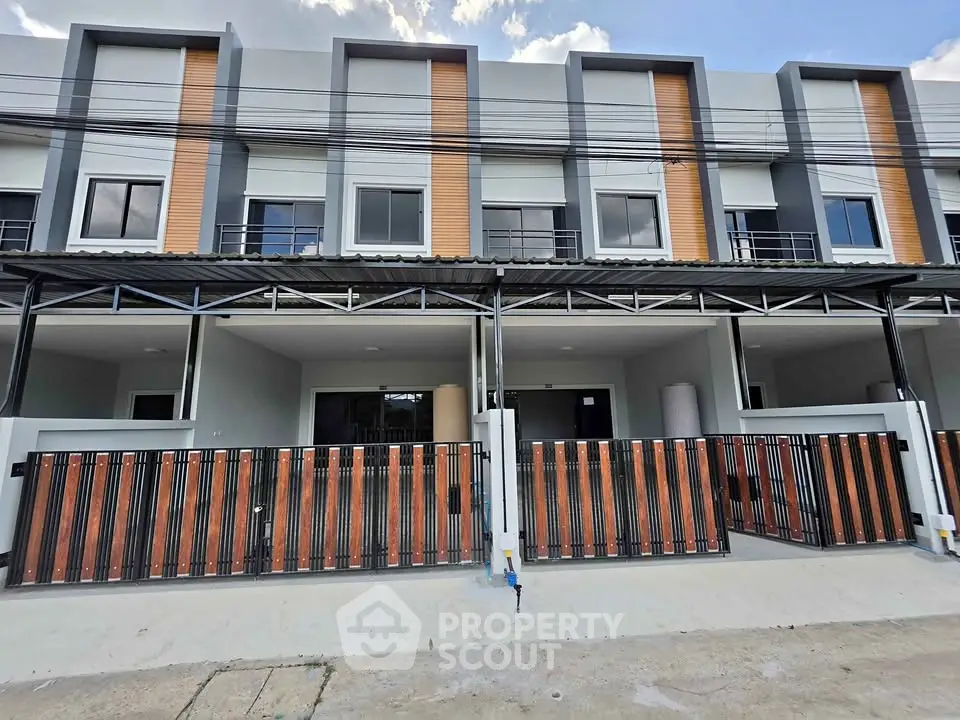 Modern townhouse exterior with sleek design and gated entrance, perfect for urban living.