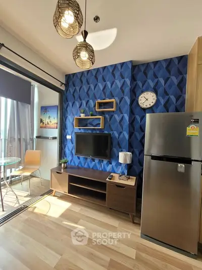Modern living room with stylish decor and balcony view, featuring a sleek fridge and wall-mounted TV.