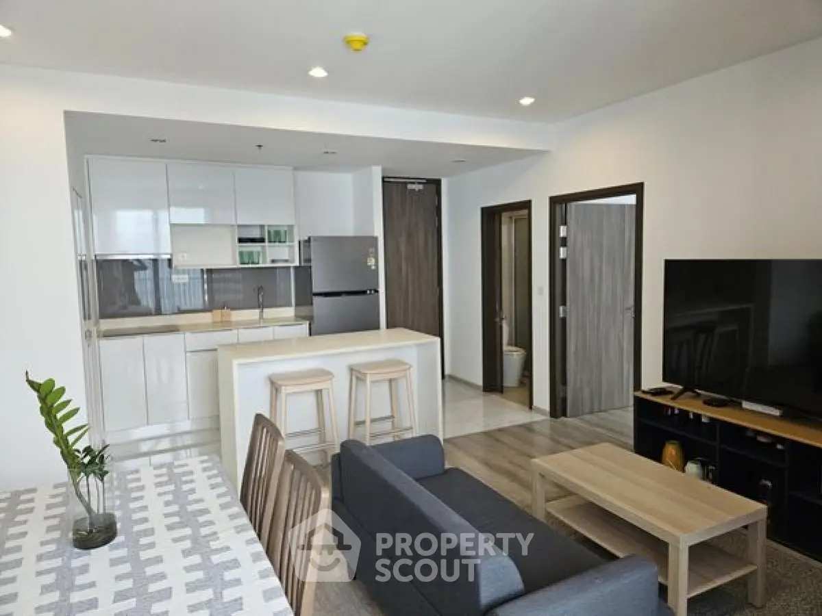 Modern open-plan living room with sleek kitchen and stylish furniture