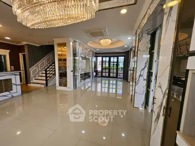 Luxurious open-plan living room with marble accents and elegant chandeliers, perfect for upscale living.
