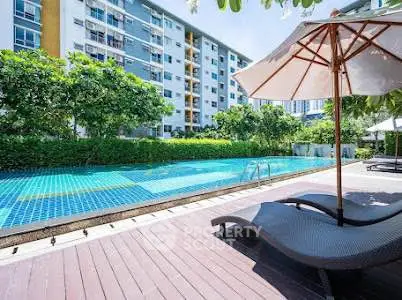 Luxurious apartment complex with inviting pool and sun loungers, perfect for relaxation and leisure.