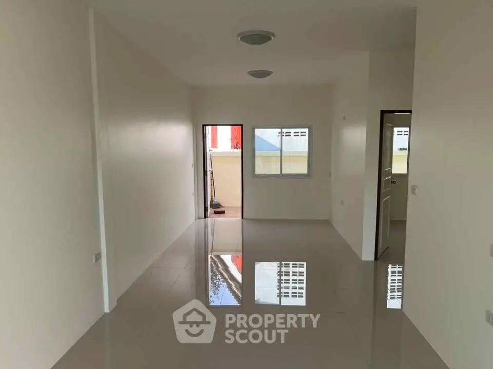 Spacious and bright living room with glossy tiled floors and large windows.