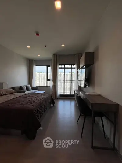 Modern bedroom with stylish furniture and large windows offering natural light and city views.