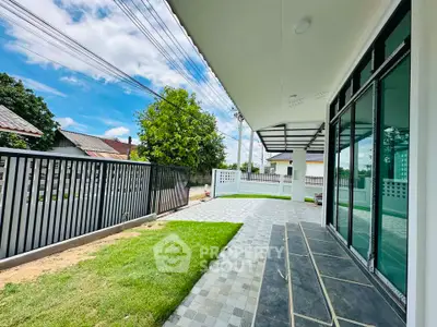 Spacious modern patio with tiled flooring and lush green lawn in a serene neighborhood.