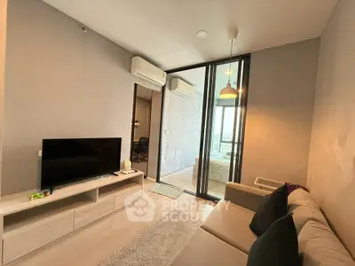 Modern living room with TV and sofa, featuring glass partition to bedroom, stylish lighting, and air conditioning.