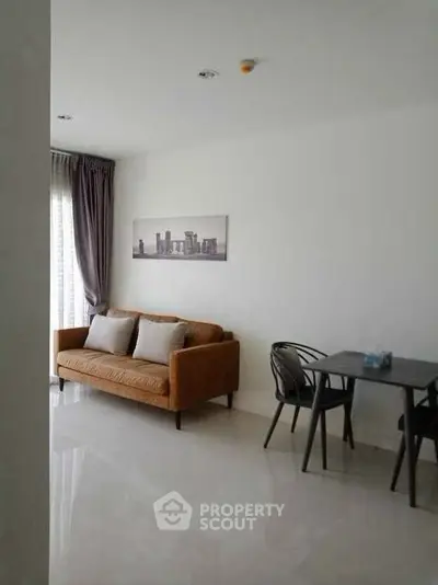 Modern living room with stylish sofa and dining area in a bright apartment.