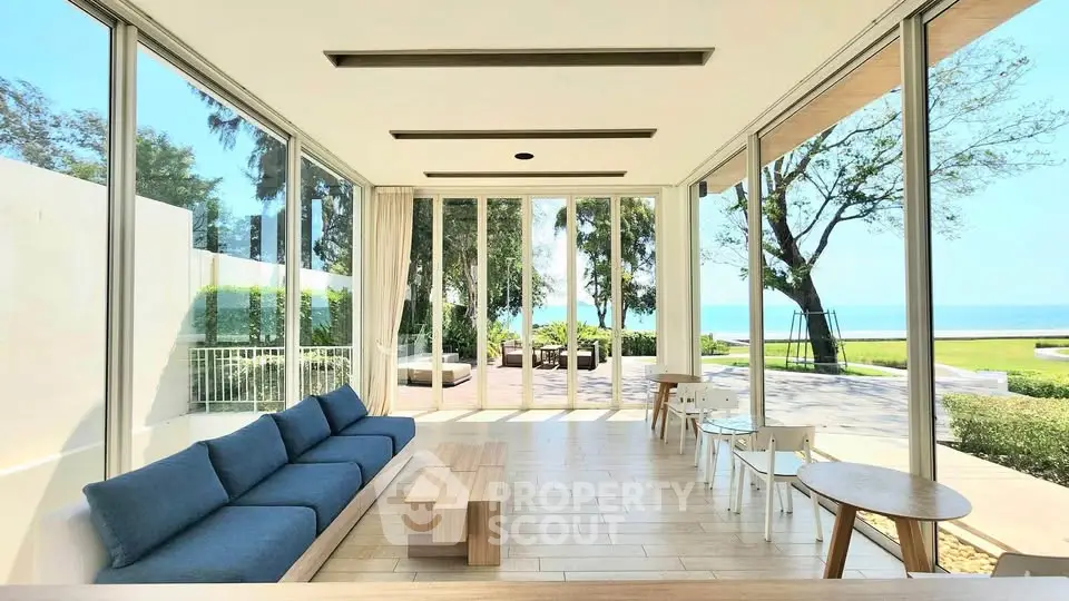 Stunning beachfront living room with panoramic ocean views and modern furnishings.