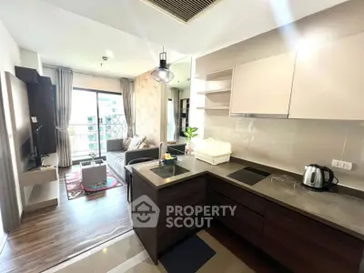 Modern open-layout kitchen and living room with stylish decor and natural light.