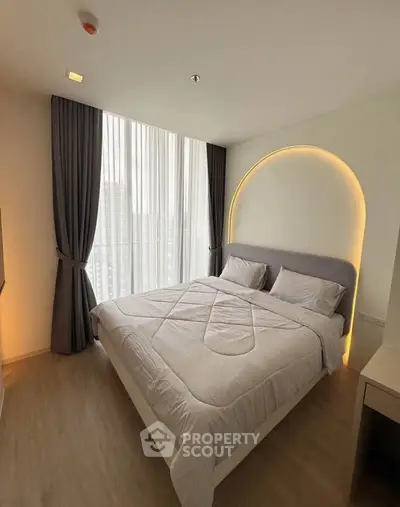 Modern bedroom with stylish lighting and large window in a high-rise apartment.