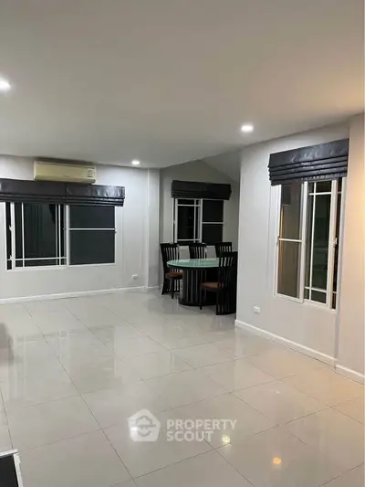 Spacious modern living room with sleek tile flooring and elegant dining area.