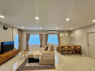 Spacious modern living room with elegant dining area and cozy seating, perfect for family gatherings.