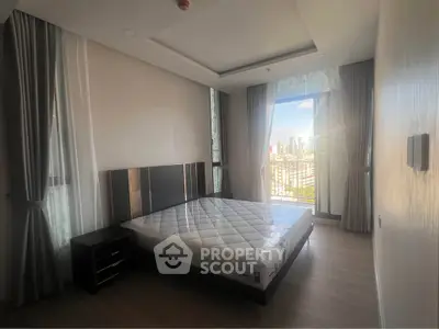 Spacious bedroom with city view and modern decor in luxury apartment