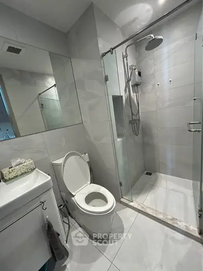 Modern bathroom with glass shower and sleek fixtures in contemporary home.