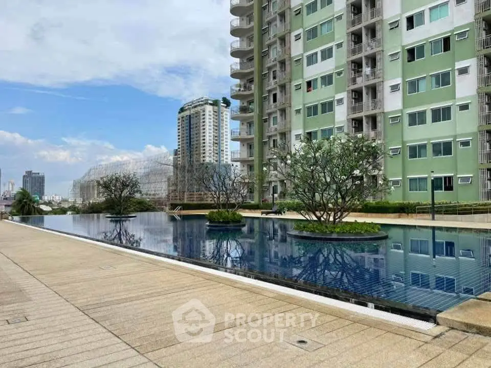 Luxurious apartment complex with stunning pool and modern architecture in urban setting.