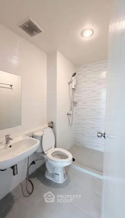 Modern minimalist bathroom with sleek white tiles and shower area