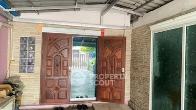 Charming entrance with wooden double doors and glass sliding door, perfect for welcoming guests.