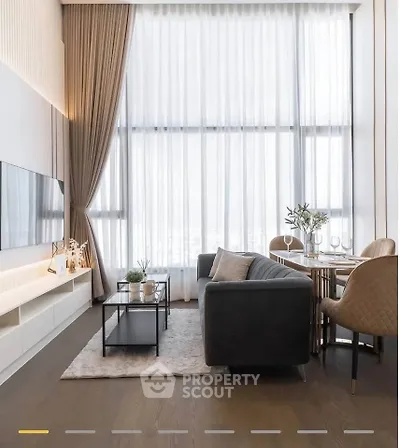 Luxurious high-ceiling living room with elegant decor and large windows.