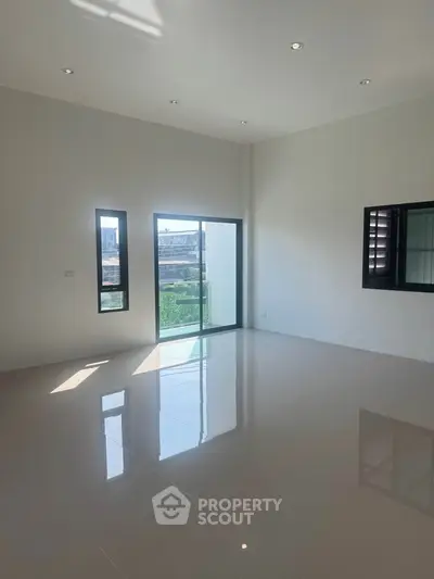 Spacious modern living room with large windows and glossy floor