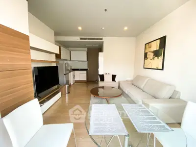 Modern living room with open kitchen, stylish furniture, and wooden accents in a contemporary apartment.