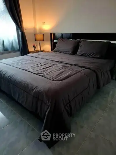 Cozy bedroom with elegant bedding and soft lighting, perfect for relaxation.