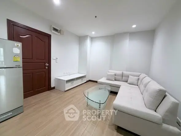 Modern living room with sleek furniture and wooden flooring in a cozy apartment.