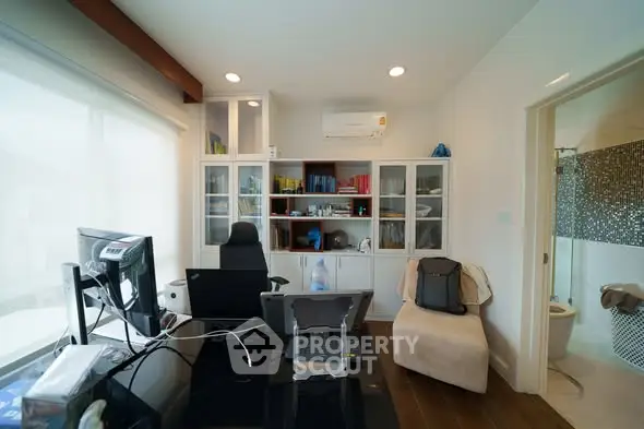Modern home office with sleek desk, dual monitors, and built-in shelving for organized workspace.