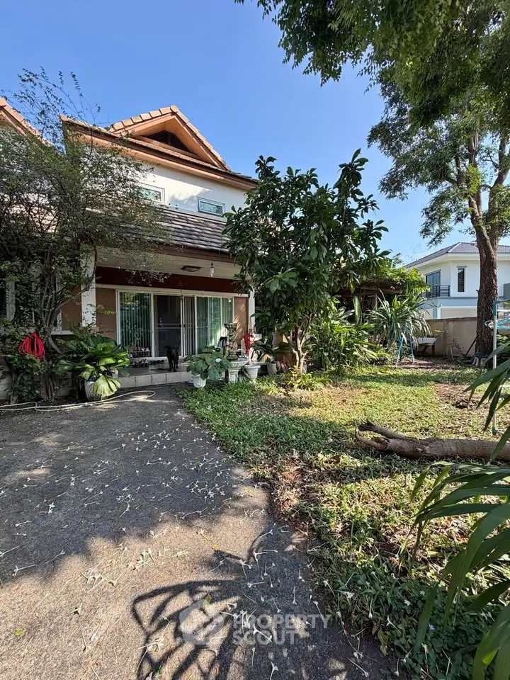 Charming two-story house with lush garden and spacious outdoor area.