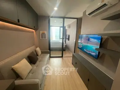 Modern living room with sleek design, featuring a cozy sofa, wall-mounted TV, and air conditioning.