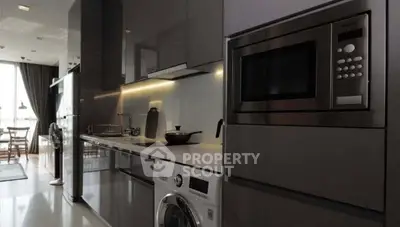 Modern kitchen with sleek appliances and glossy cabinetry in a stylish apartment.