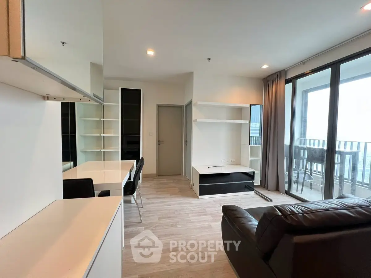Modern living room with sleek furniture and large balcony view