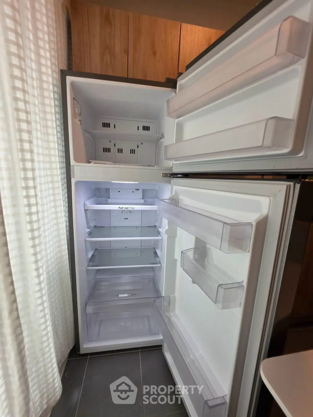 Spacious open refrigerator in modern kitchen setting with ample storage.