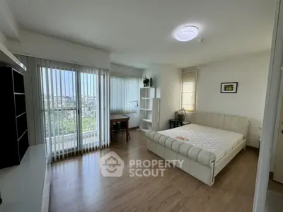 Spacious bedroom with large windows and balcony view in modern apartment